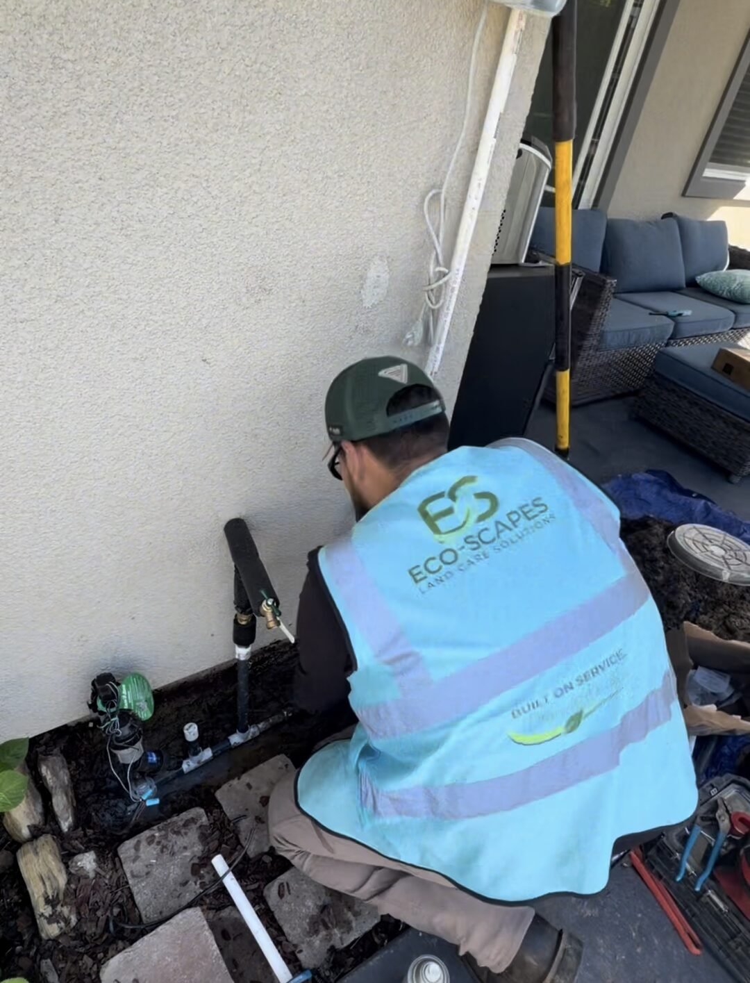 Eco-Scapes technician servicing hose bib and backflow plumbing at a Dixon CA home