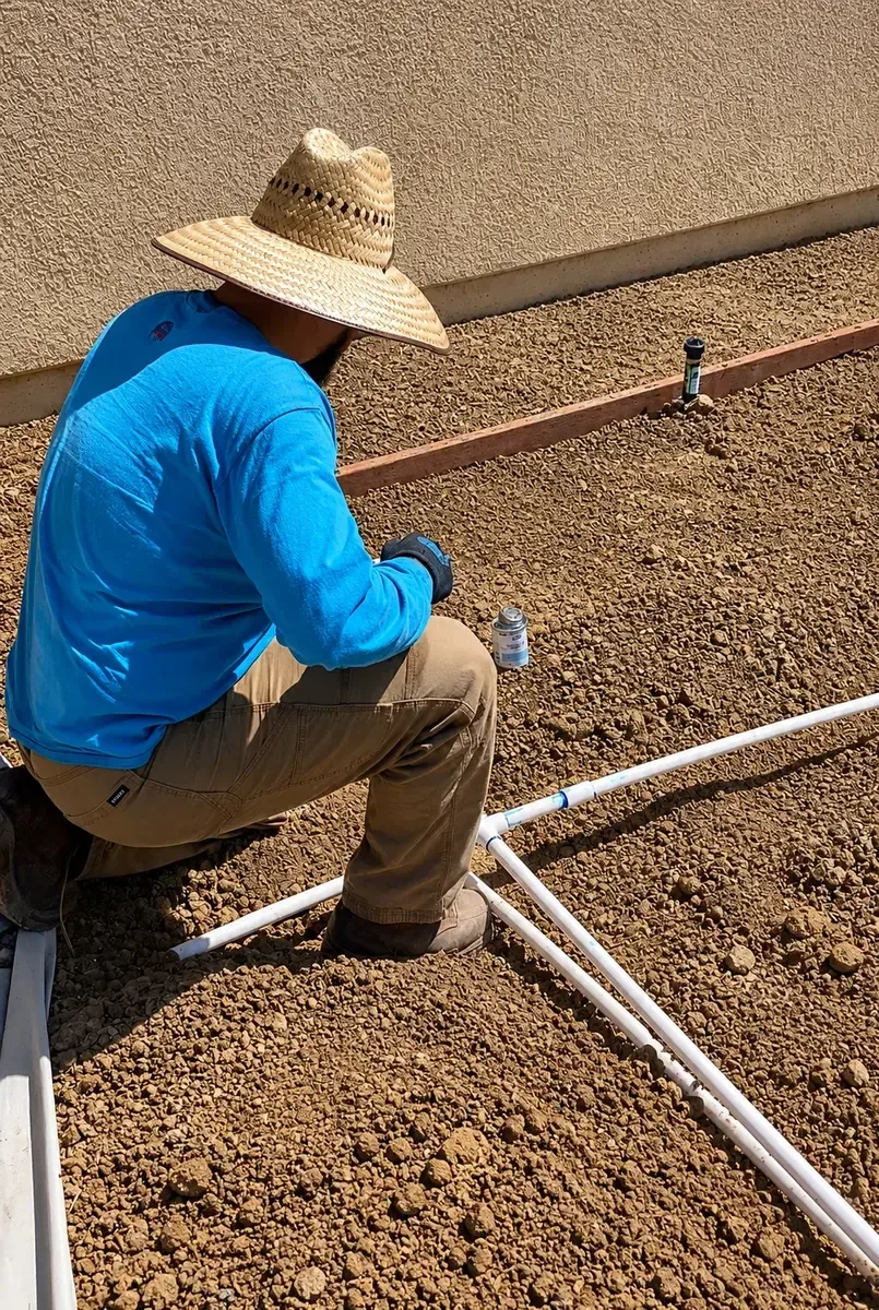 Technician crouching over a residential irrigation valve box in Solano County California